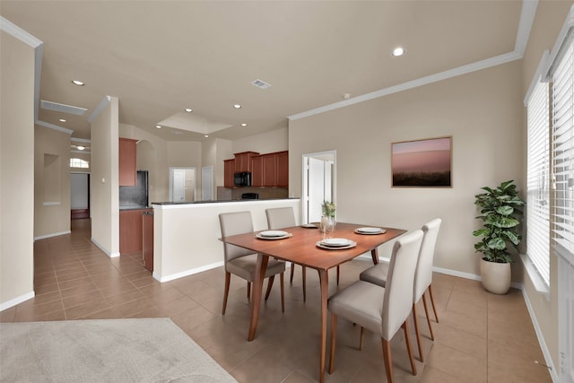 tiled dining room featuring ornamental molding