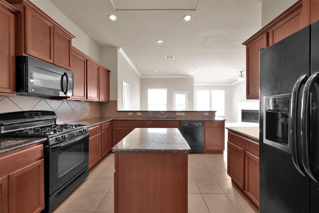 kitchen with black appliances, light tile patterned floors, decorative backsplash, sink, and a center island