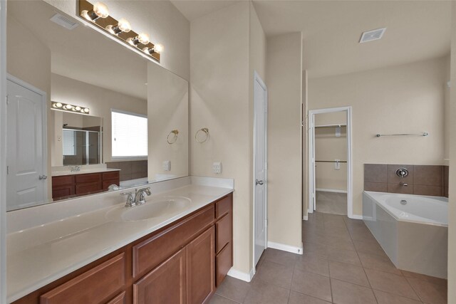 bathroom with shower with separate bathtub, vanity, and tile patterned floors