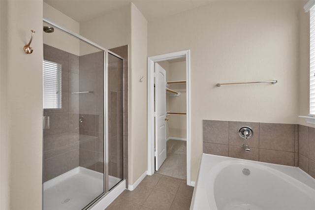 bathroom with a wealth of natural light, tile patterned floors, and independent shower and bath