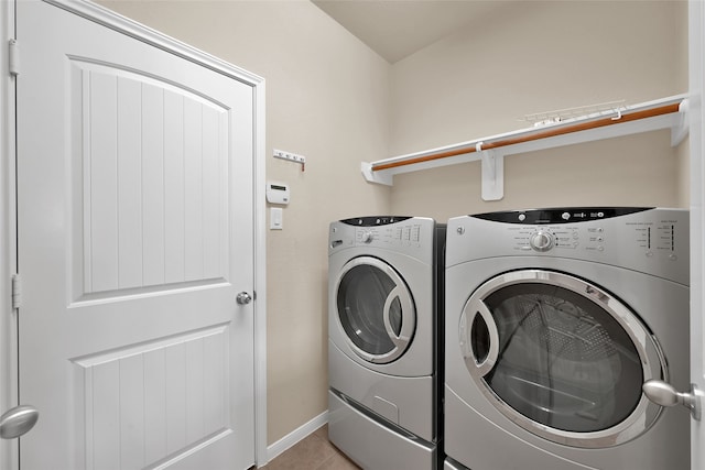 laundry room with independent washer and dryer and light tile patterned floors