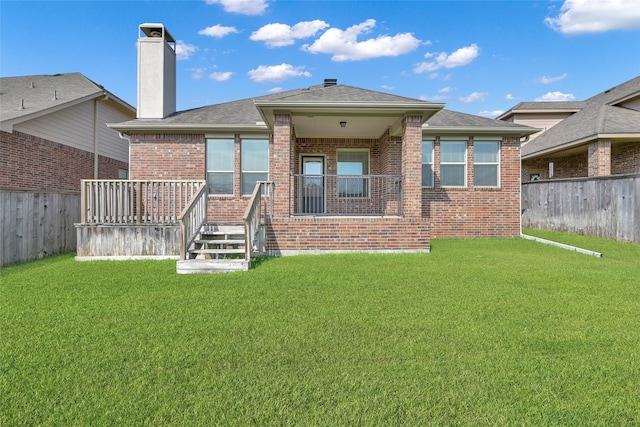 rear view of house featuring a deck and a yard