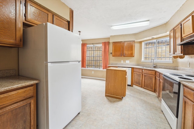 kitchen with a textured ceiling, a wealth of natural light, sink, and white appliances