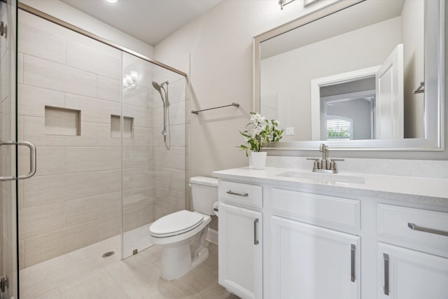 bathroom featuring vanity, toilet, and a shower with door