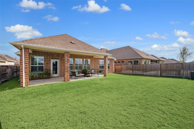 back of property with a yard, a patio, and an outdoor living space