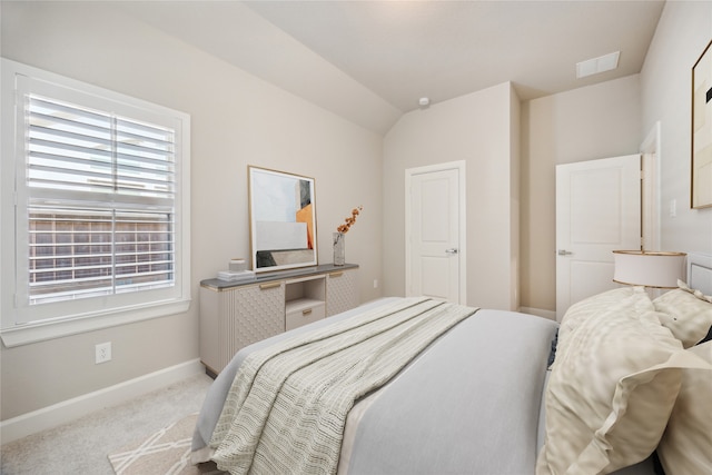 bedroom featuring light colored carpet and lofted ceiling