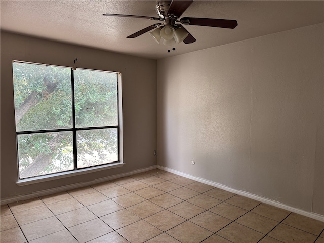 tiled spare room featuring a healthy amount of sunlight and ceiling fan