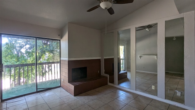 unfurnished living room featuring ceiling fan, vaulted ceiling, light tile patterned flooring, and a fireplace