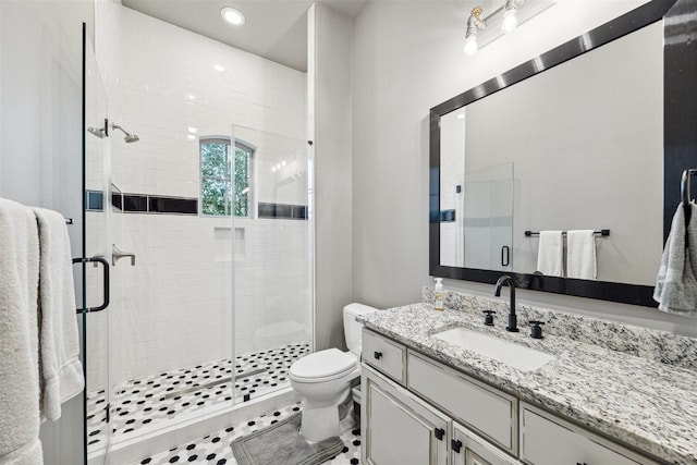 bathroom featuring toilet, a shower stall, and vanity