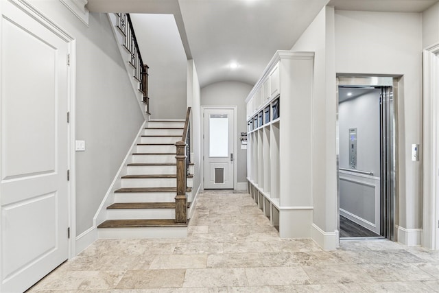 mudroom featuring lofted ceiling, elevator, and baseboards