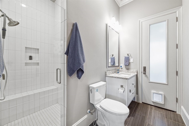 full bath featuring toilet, a shower stall, baseboards, and vanity