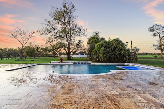 pool at dusk featuring a yard and a patio area