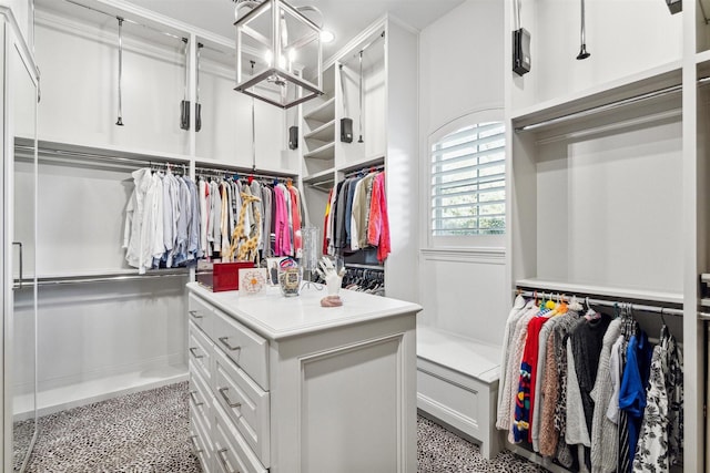 walk in closet featuring a notable chandelier