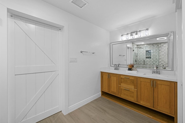 bathroom featuring hardwood / wood-style flooring, vanity, and an enclosed shower