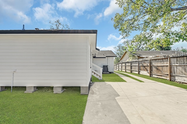 view of side of property with a lawn, a patio area, and central air condition unit