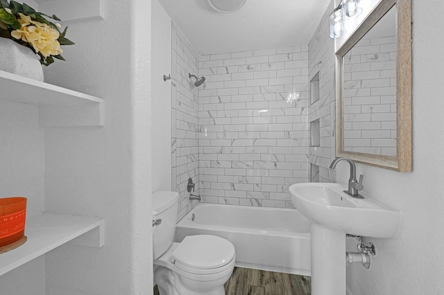 bathroom featuring toilet, tiled shower / bath combo, and hardwood / wood-style flooring