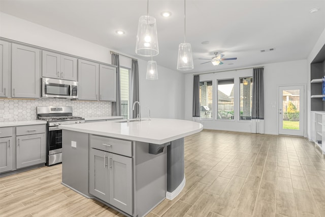 kitchen featuring ceiling fan, sink, gray cabinets, and stainless steel appliances