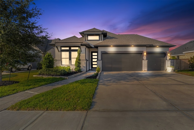 prairie-style home with a yard and a garage