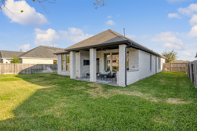 rear view of property with a lawn, a patio area, and ceiling fan