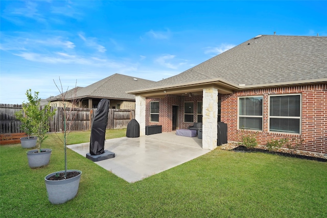 rear view of house featuring a lawn and a patio