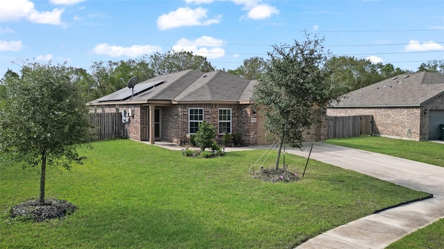 view of front facade featuring solar panels and a front yard