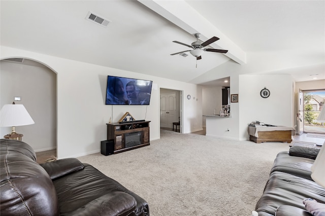 carpeted living room with vaulted ceiling with beams and ceiling fan