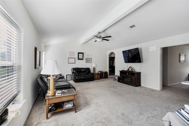 carpeted living room with vaulted ceiling with beams and ceiling fan