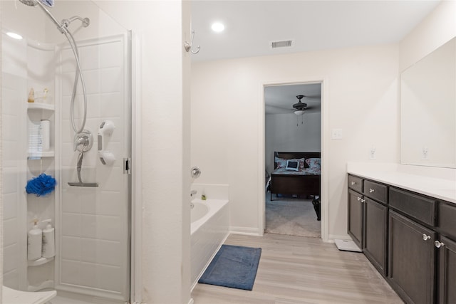 bathroom featuring hardwood / wood-style floors, vanity, ceiling fan, and plus walk in shower