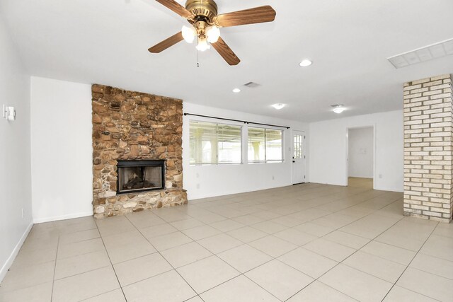 unfurnished living room with a fireplace, light tile patterned floors, and ceiling fan