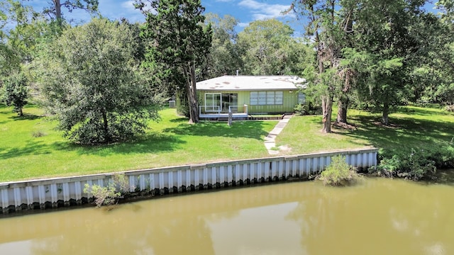 back of property featuring a lawn and a water view