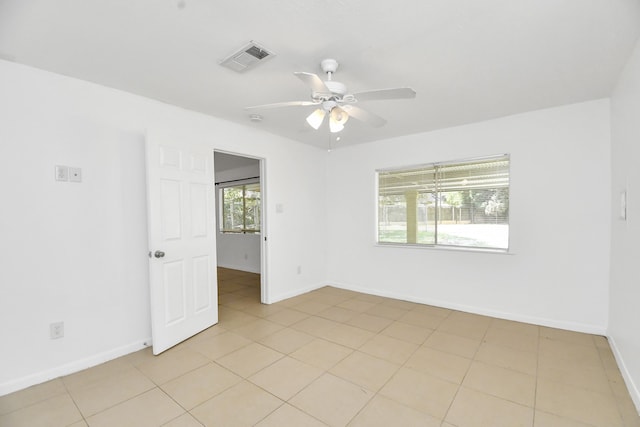 tiled spare room with ceiling fan