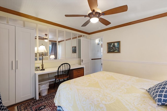 bedroom with dark hardwood / wood-style flooring, ornamental molding, ceiling fan, built in desk, and a closet