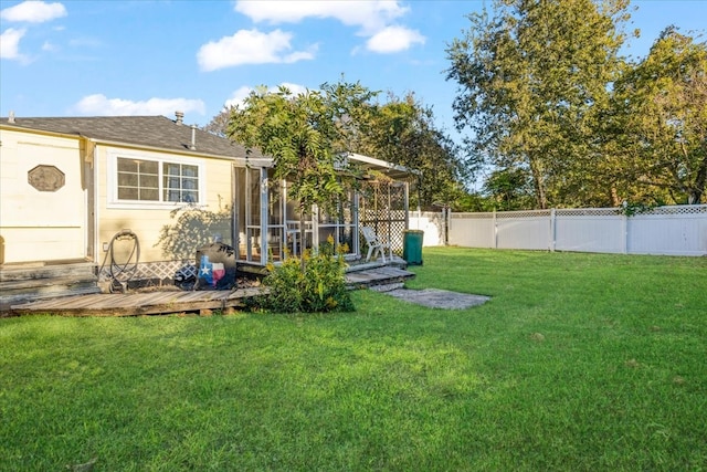 view of yard featuring a sunroom and a deck