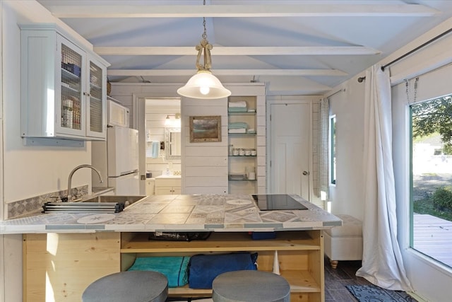 kitchen with a kitchen breakfast bar, decorative light fixtures, beamed ceiling, white cabinets, and dark hardwood / wood-style floors