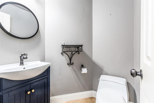 bathroom featuring vanity, hardwood / wood-style floors, and toilet