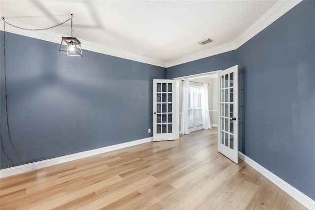 empty room featuring ornamental molding, light hardwood / wood-style flooring, and french doors