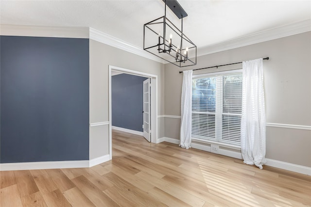 unfurnished dining area with hardwood / wood-style floors, crown molding, and a chandelier