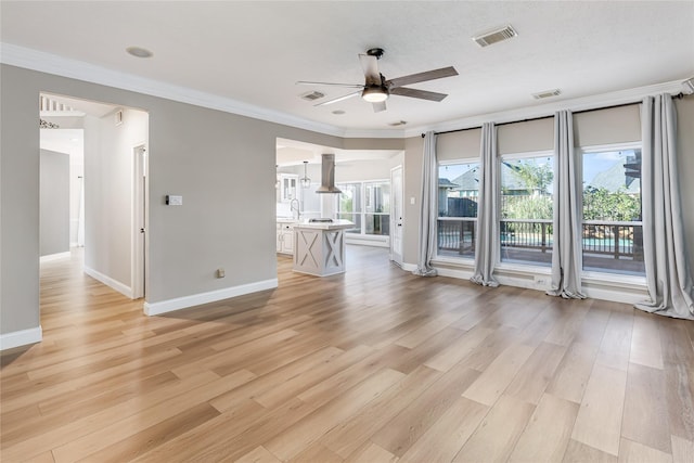 unfurnished living room featuring crown molding, ceiling fan, and light hardwood / wood-style flooring