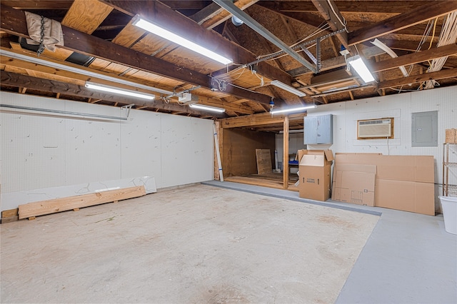 basement with an AC wall unit and electric panel