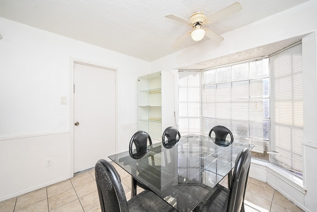 tiled dining space with ceiling fan and a textured ceiling