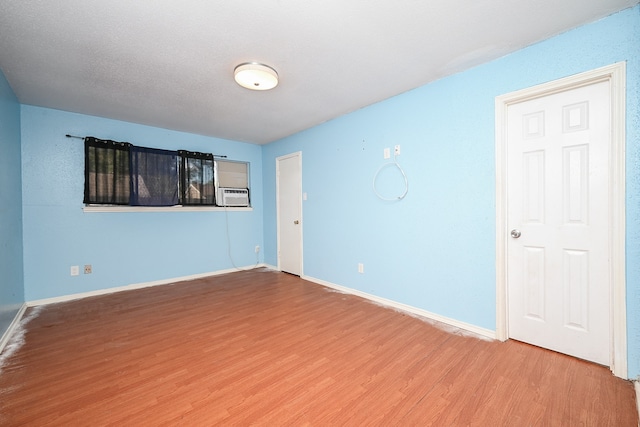 unfurnished room featuring cooling unit and wood-type flooring