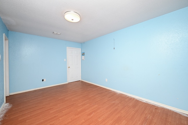 unfurnished room with wood-type flooring