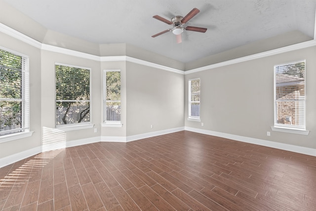 spare room with a textured ceiling, ceiling fan, a healthy amount of sunlight, and dark hardwood / wood-style floors