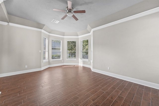 empty room with a textured ceiling, dark hardwood / wood-style floors, ceiling fan, and crown molding