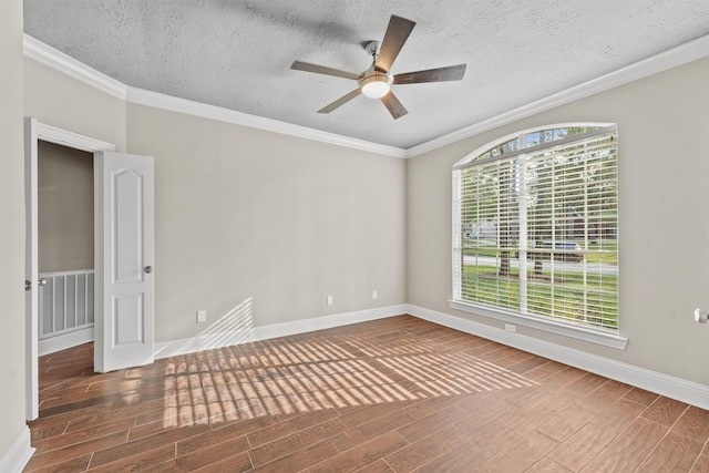 empty room with ceiling fan, hardwood / wood-style floors, a textured ceiling, and ornamental molding