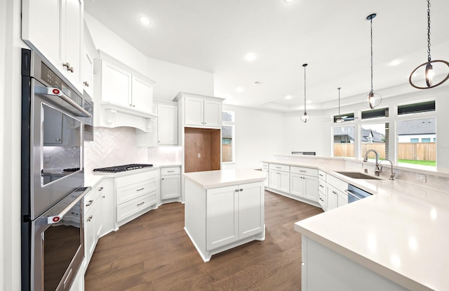 kitchen featuring pendant lighting, dark hardwood / wood-style floors, a kitchen island, and sink