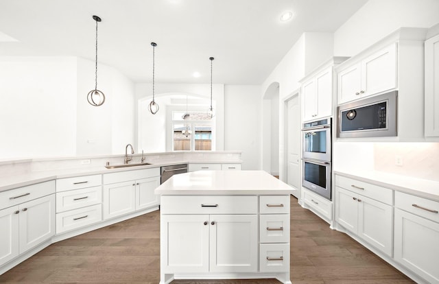 kitchen with dark hardwood / wood-style floors, sink, stainless steel appliances, and hanging light fixtures