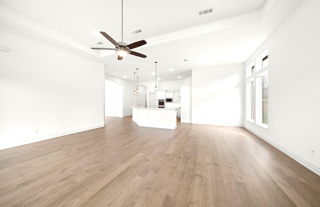 unfurnished living room with ceiling fan and light hardwood / wood-style floors