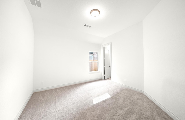 carpeted empty room featuring vaulted ceiling