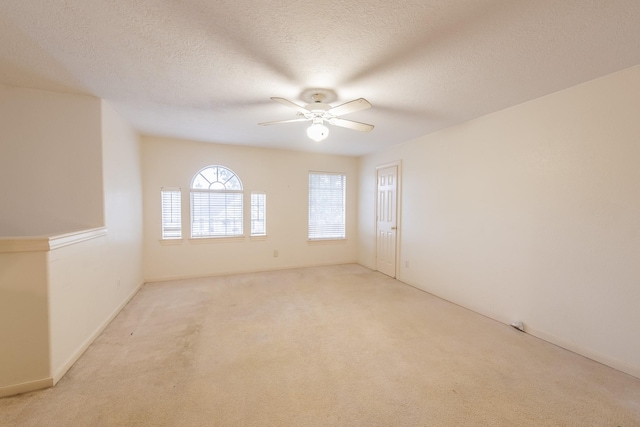 carpeted empty room featuring ceiling fan and a textured ceiling